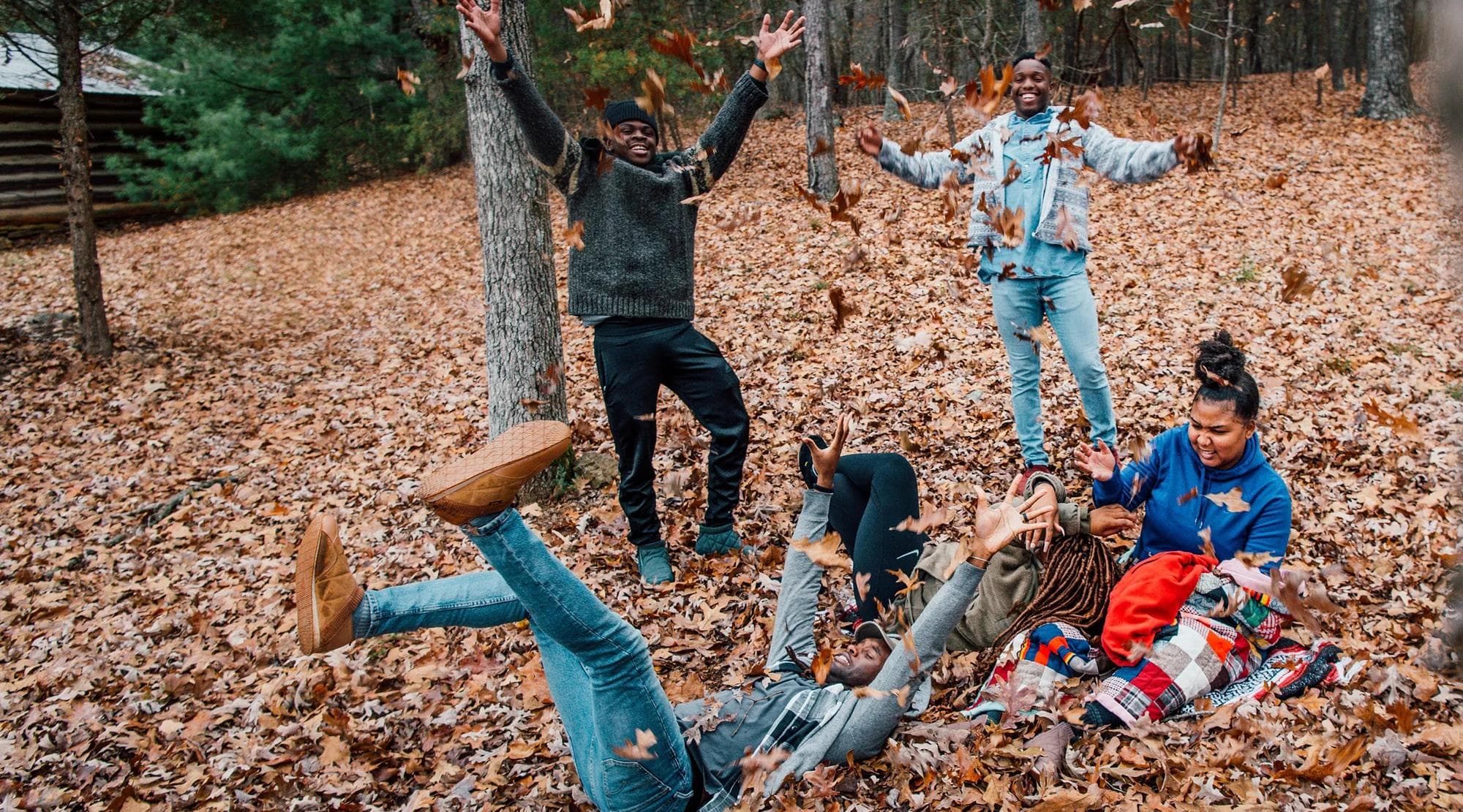 HBCU student playing in fall leaves